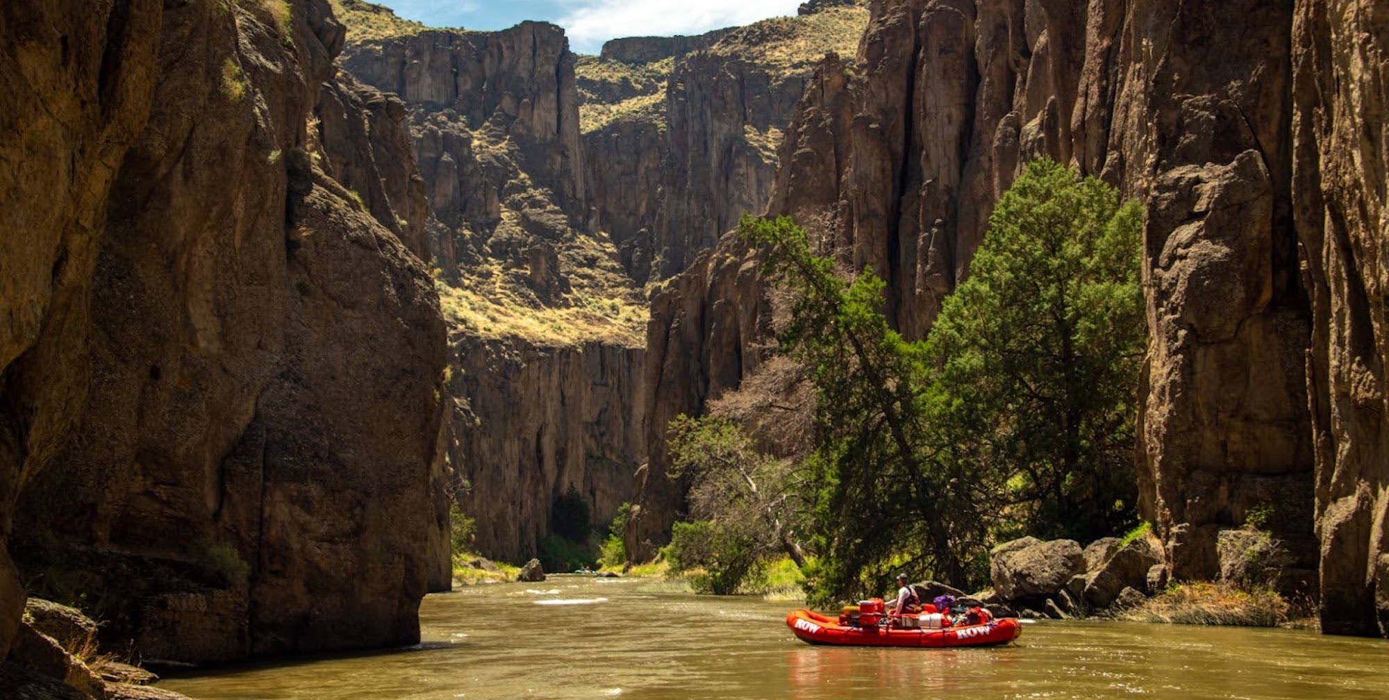 Person rowing a red raft down the Bruneau River in Southwestern Idaho