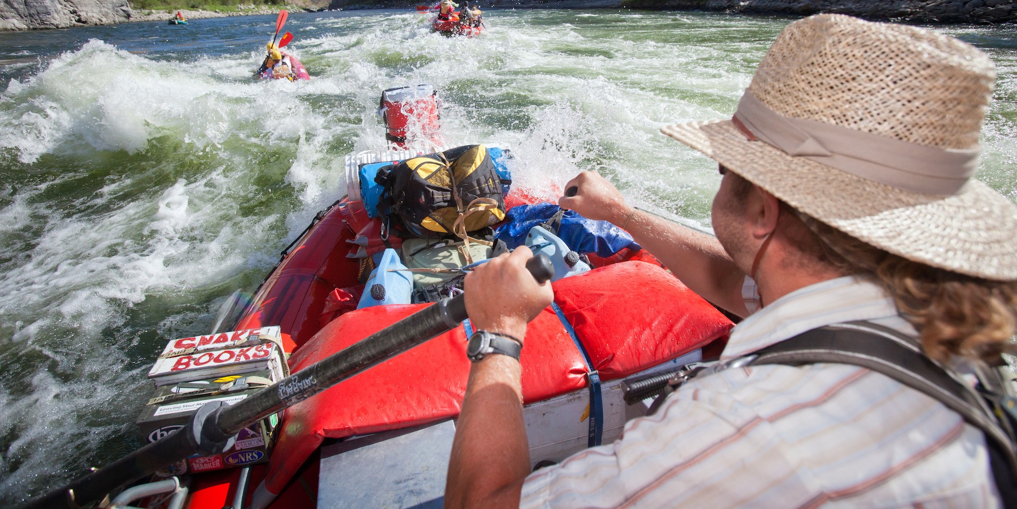 River guide rowing a boat full of gear through a rapid on the Snake River through Hells Canyon