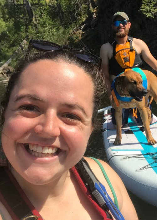 woman, man and dog floating on water with paddleboard