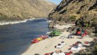 Tents and other gear sprawled out on a white sand beach in the middle of a multi-day rafting trip down the Snake River through Hells Canyon