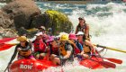 red paddle raft with people paddling in big rapid on the snake river 